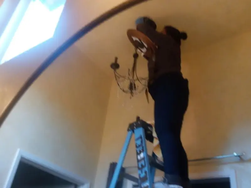 Electrician installing a chandelier in a San Martin residence